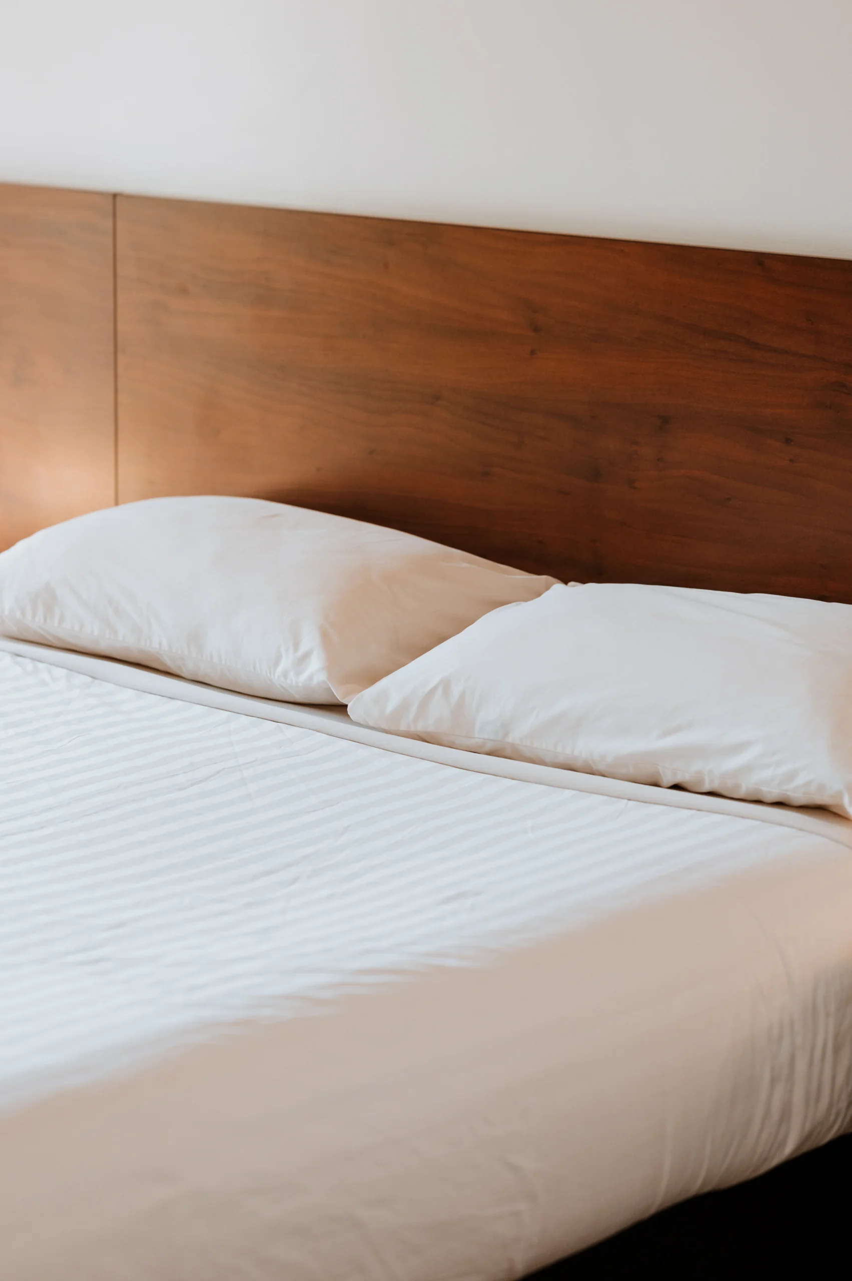 Close up of sheets and pillows on bed. The sheets and pillow cases are crisp and white