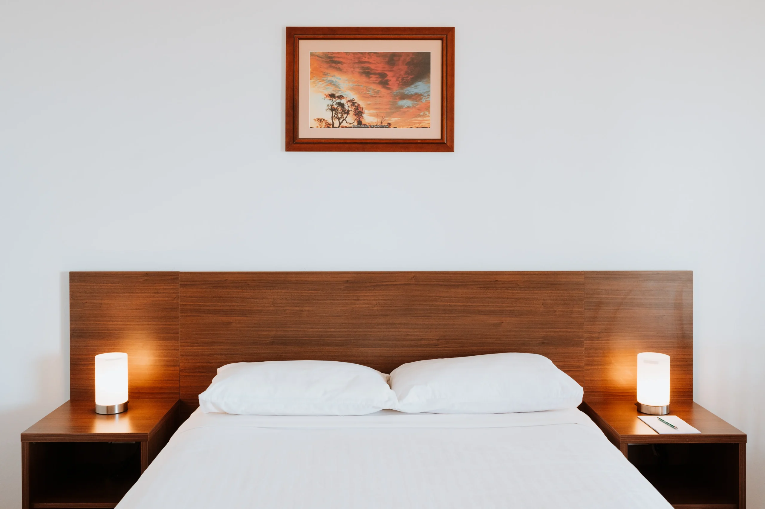 feature image of queen bed with stylish brown headboard and matching art