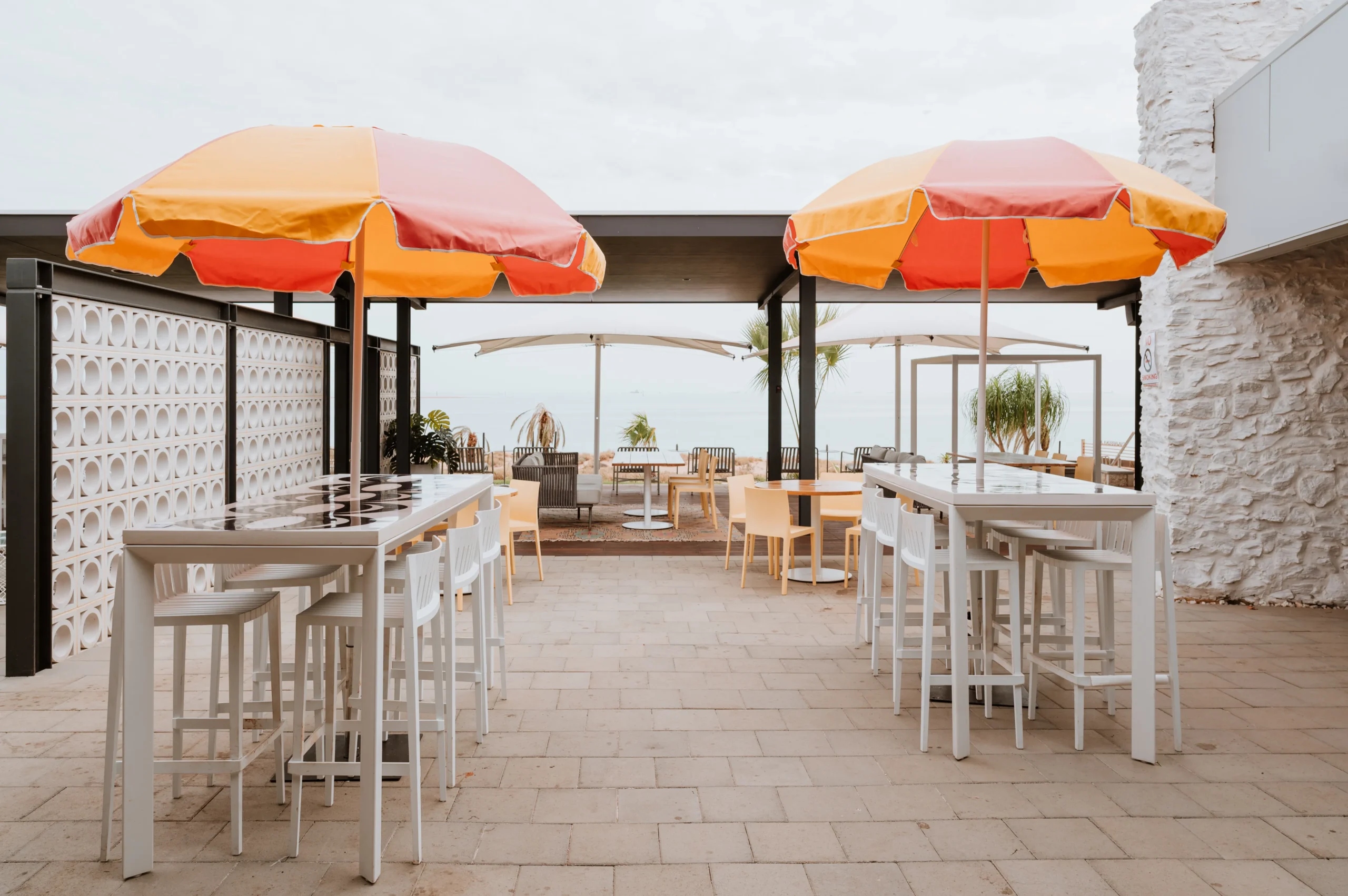 Photo of the exterior dining area at Rays Port Hedland with beach umbrellas and the ocean in the background