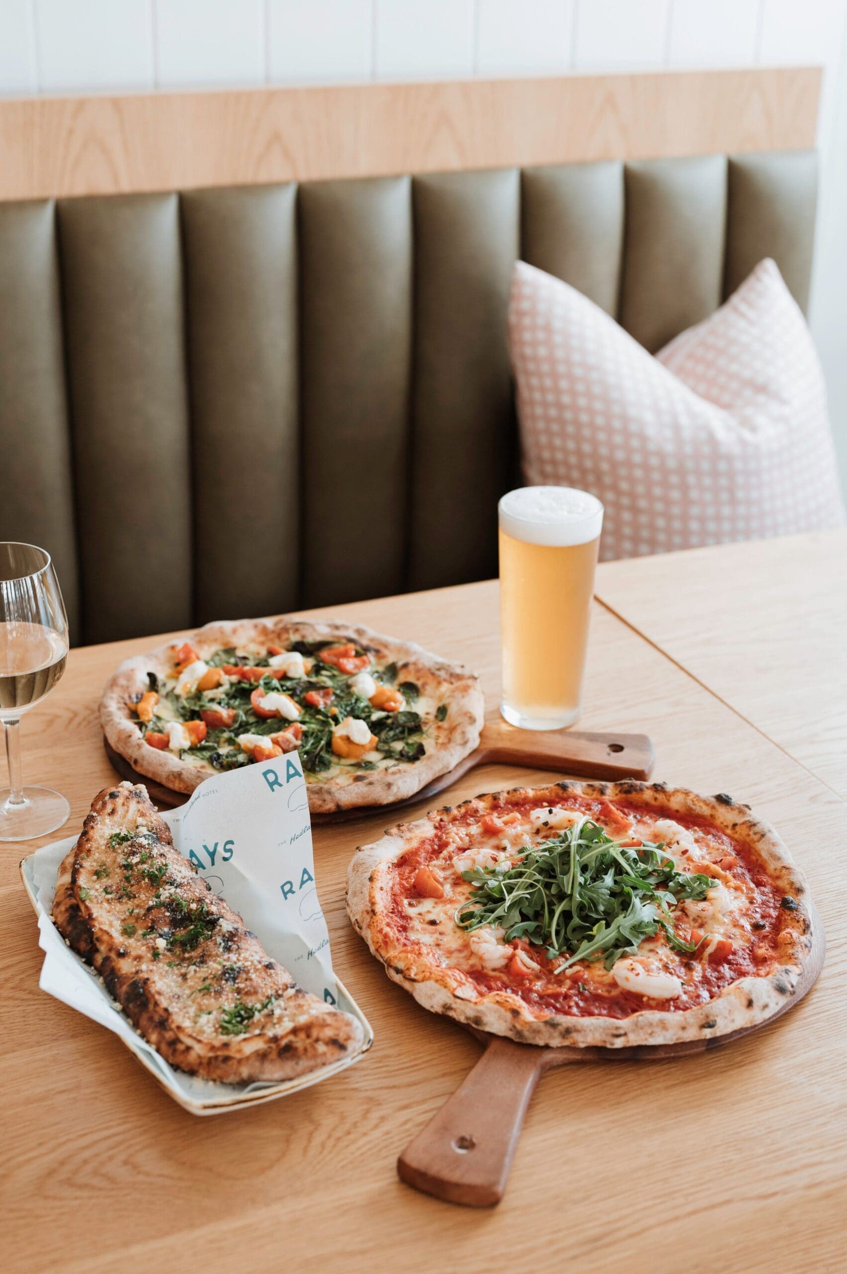 Interior dining at the Hedland Hotel, showing pizzas and beer on a cosy table