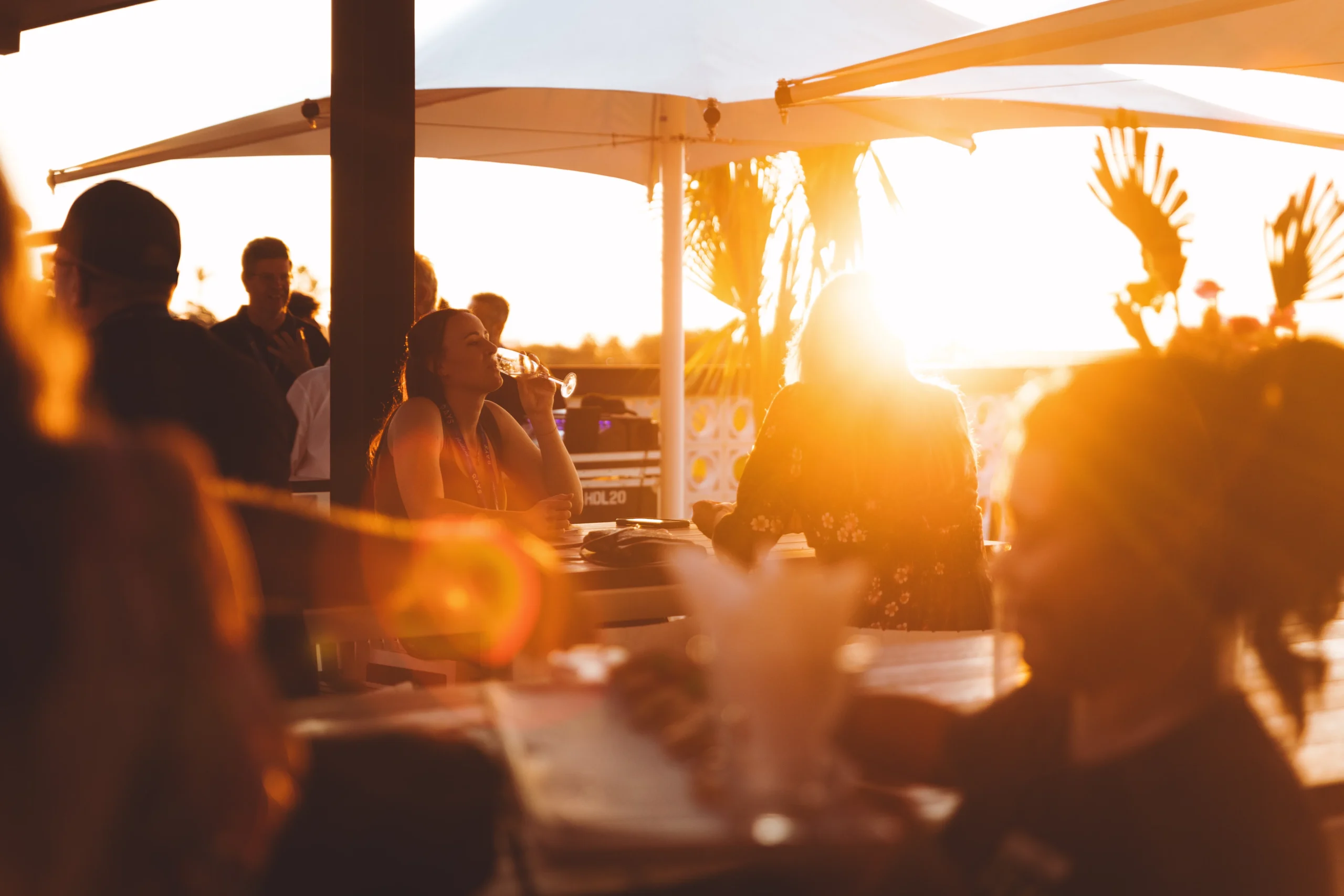 photo of guests enjoying a drink at rays with the sun shining through before sunset